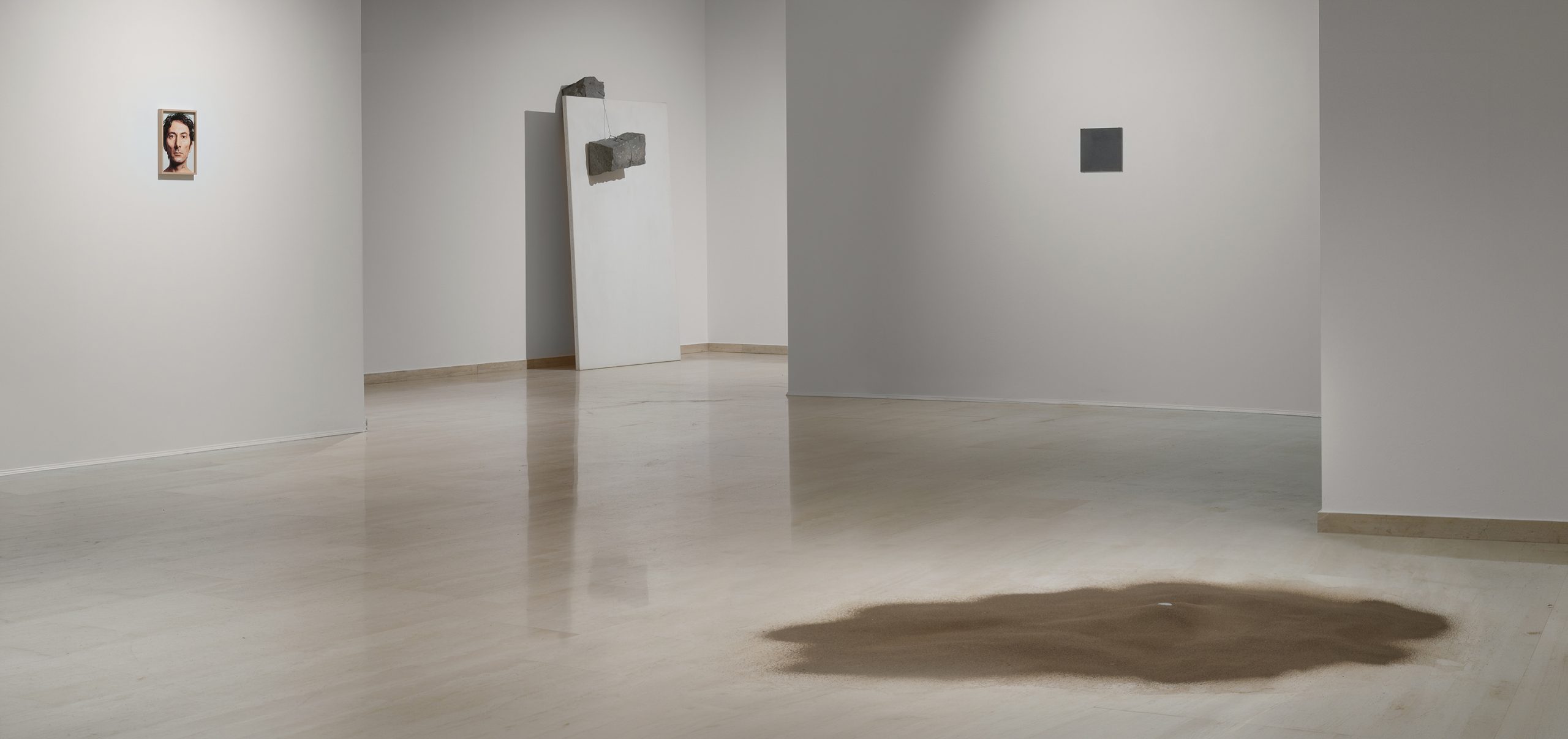 Installation view of Giovanni Anselmo’s exhibition at Repetto Gallery in Lugano, with artworks displayed throughout the white gallery space.